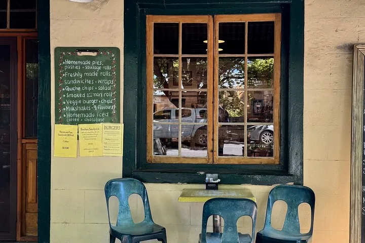 Cafe window and chairs with a handwritten menu board in Hahndorf