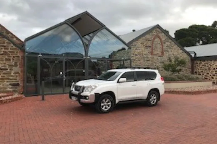 The tour car outside a stone cellar door with a glass entrance