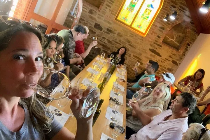 Guests tasting wine in a stone chapel with stained glass