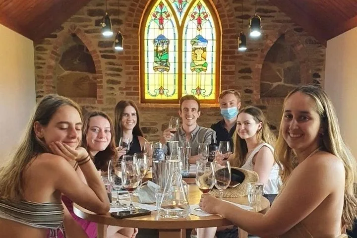 Guests at a wine tasting under a stained-glass window